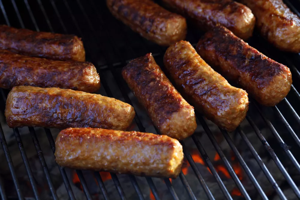 Close-up of roasted cevapi, cevapcici on the grill over glowing charcoal, traditional Balkan meat sausages on the bbq. / Foto: Andreas H&auml;uslbetz
