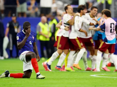 Soccer Football - FIFA World Cup 2026 - Semi Final - France v Spain - Dallas Stadium, Arlington, Texas, U.S. - July 14, 2026 France's Dayot Upamecano look dejected after the match as France are eliminated as Spain players celebrate after qualifying for the World Cup final REUTERS/Albert Gea