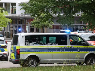 Police vehicles are parked in front of the Welfen High School, Schongau, Germany, Wednesday, July 8, 2026. (Karl-Josef Hildenbrand/dpa via AP)