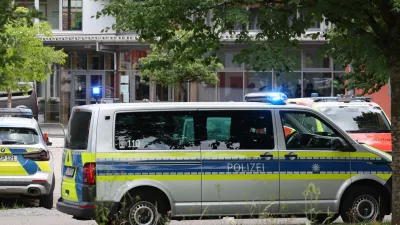 Police vehicles are parked in front of the Welfen High School, Schongau, Germany, Wednesday, July 8, 2026. (Karl-Josef Hildenbrand/dpa via AP)