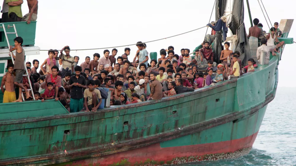 Migrants sit on their boat as they wait to be rescued by Acehnese fishermen on the sea off East Aceh, Indonesia, Wednesday, May 20, 2015. Hundreds of migrants stranded at sea for months were rescued and taken to Indonesia, officials said Wednesday, the latest in a stream of Rohingya and Bangladeshi migrants to reach shore in a growing crisis confronting Southeast Asia. (AP Photo/S. Yulinnas)