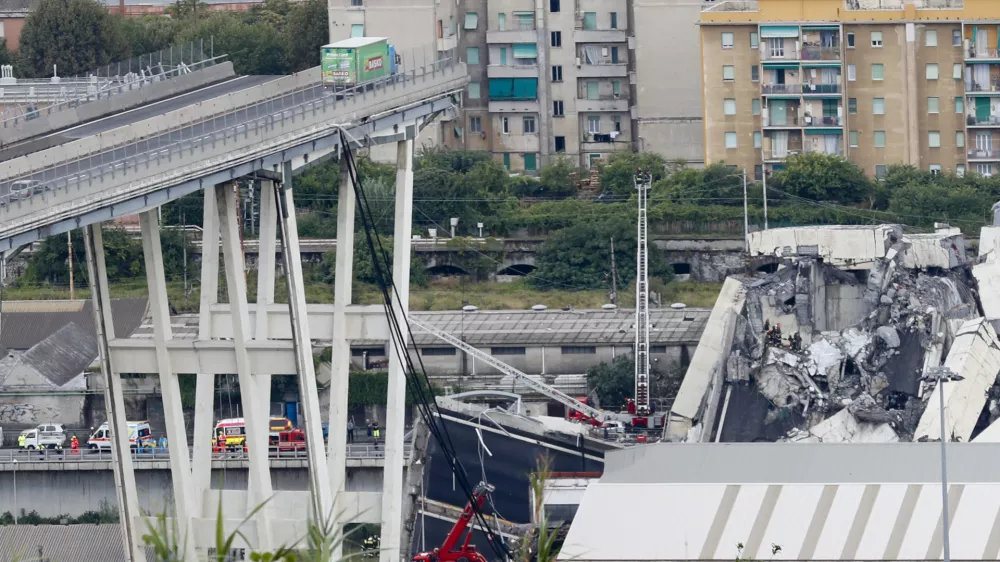 Cars are blocked on the Morandi highway bridge after a section of it collapsed, in Genoa, northern Italy, Tuesday, Aug. 14, 2018. A large section of the bridge collapsed over an industrial area in the Italian city of Genova during a sudden and violent storm, leaving vehicles crushed in rubble below. (AP Photo/Antonio Calanni)