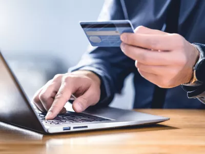Safe online payment and electronic money transfer security. Pay with digital technology. Man using credit card and laptop to login to internet bank. Financial safety to prevent scam, threat and fraud.