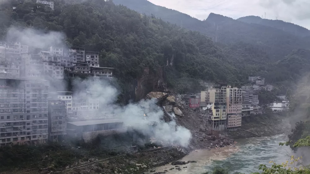 In this photo taken and provided by Mimosa shows smoke rise as resident buildings toppled by rocks and muds following a landslide in Pengshui County in southwestern China's Chongqing on Friday, July 17, 2026. (Mimama via AP)