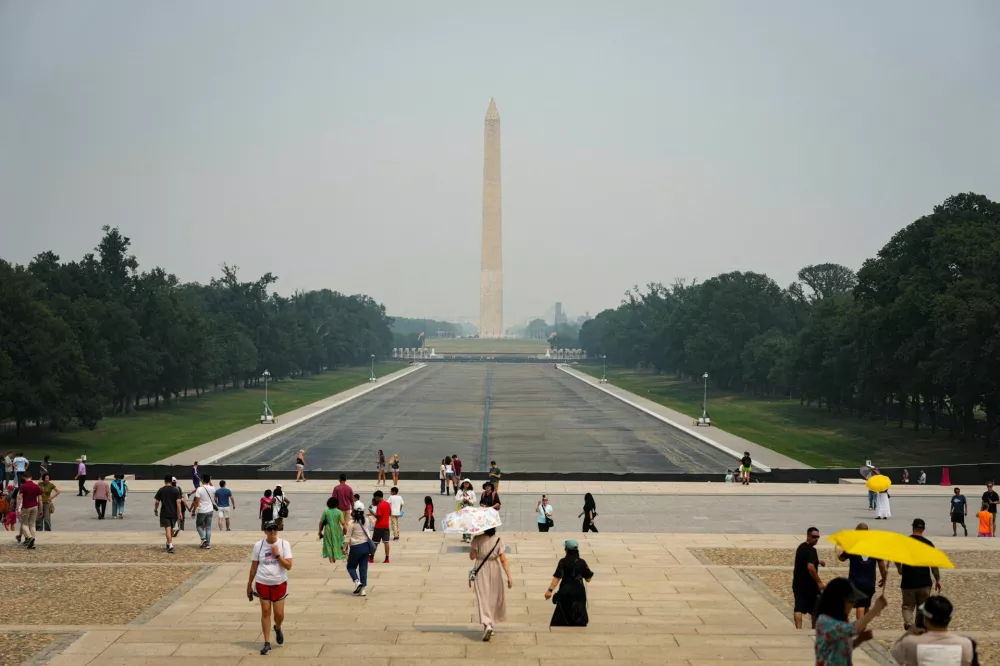 Pedestrians walk near the drained Lincoln Memorial Reflecting Pool in smoky conditions due to the Canadian wildfires, in Washington, D.C., U.S., July 17, 2026. REUTERS/Al Drago