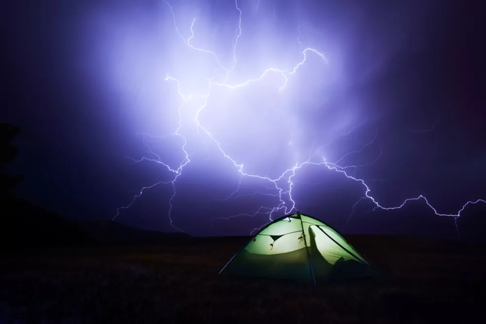 Incredible sky with lightning and tent camp. Danger tourism concept