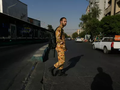 An army soldier crosses the Islamic Revolution Street in downtown Tehran, Iran, Saturday, July 18, 2026. (AP Photo/Vahid Salemi)
