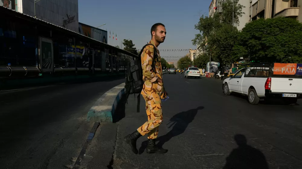 An army soldier crosses the Islamic Revolution Street in downtown Tehran, Iran, Saturday, July 18, 2026. (AP Photo/Vahid Salemi)