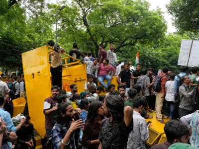 Supporters of the Cockroach Janta Party shout anti government slogans sitting on a police barricade as they they attempt to march toward India's Parliament, demanding the resignation of the education minister, in New Delhi, India, Monday, July 20, 2026. (AP Photo/Manish Swarup)