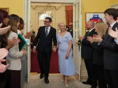 Staff clap as new Prime Minister Andy Burnham and wife Marie-France van Heel walk into 10 Downing Street in London, Monday, July 20, 2026. (AP Photo/Kin Cheung, Pool)