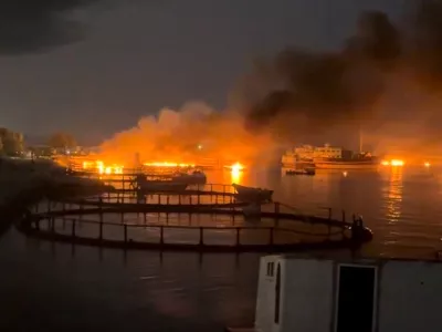 Smoke rises from a port, near Strait of Hormuz, following a U.S. strike in Kuhestak, Hormozgan Province, Iran, July 8, 2026, in this screengrab obtained from a social media video. Social Media/via REUTERS THIS IMAGE HAS BEEN SUPPLIED BY A THIRD PARTY. MANDATORY CREDIT. NO RESALES. NO ARCHIVES. NEWS USE ONLY. Verification line: Reuters confirmed the location by matching the port layout visible in the video with satellite imagery. The coordinates are 26.801109802855272, 57.02121784040872. The date the video was filmed was verified through a report from Iran's semi-official Mehr News Agency, which reported explosions early on July 8 at multiple locations along the Gulf coast, including Kuhestak. Aftermath photographs shared online on July 8 also showed damage at the same location. No earlier versions of the footage or photographs posted before July 8 were found.