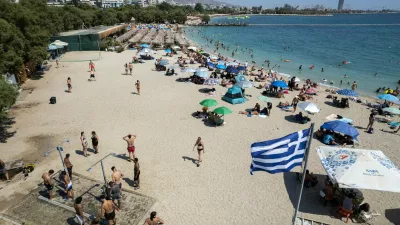 People gather at a beach as temperatures reached 39 Celsius degrees, (102.2 Fahrenheit), at Alimos suburb, south of Athens, Greece, on Sunday July 19, 2026. (AP Photo/Yorgos Karahalis)
