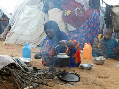 An internally displaced woman prepares breakfast outside their makeshift shelter during a visit by World Food Programme's Assistant Executive Director for Programme Operations, Matthew Hollingworth (not in the photo), to assess the knock on effects from the escalation in the Middle East, alongside drought and sharp cuts in humanitarian funding that are worsening hunger, in Kahda district of Mogadishu, Somalia May 7, 2026. REUTERS/Feisal Omar
