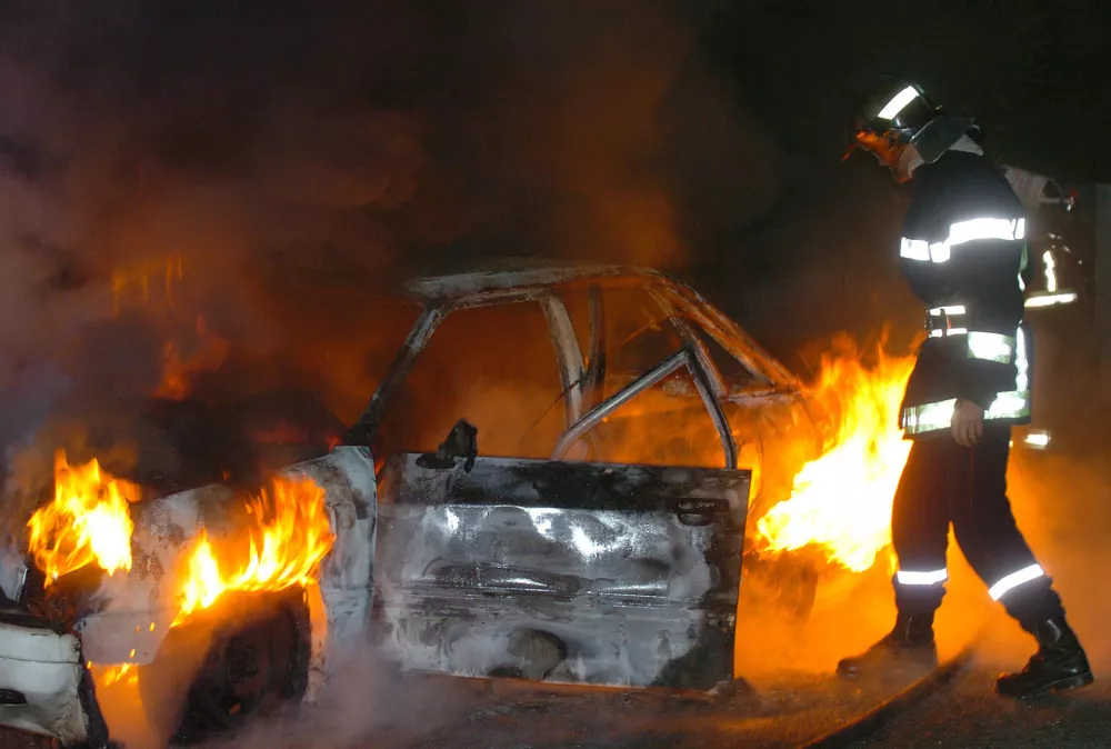 A firefighter extinguishes cars in Cenon, near Bordeaux, southwestern France, Monday night, Nov. 7, 2005 on the 12th day of unrest. Vehicles and buildings were torched by youths in largely immigrant areas throughout France after two of their peers were electrocuted last week at a power substation while hiding from police they feared were chasing them, but it has grown into a nationwide insurrection by suburban youth burning and clashing with police. (AP Photo/Bob Edme).