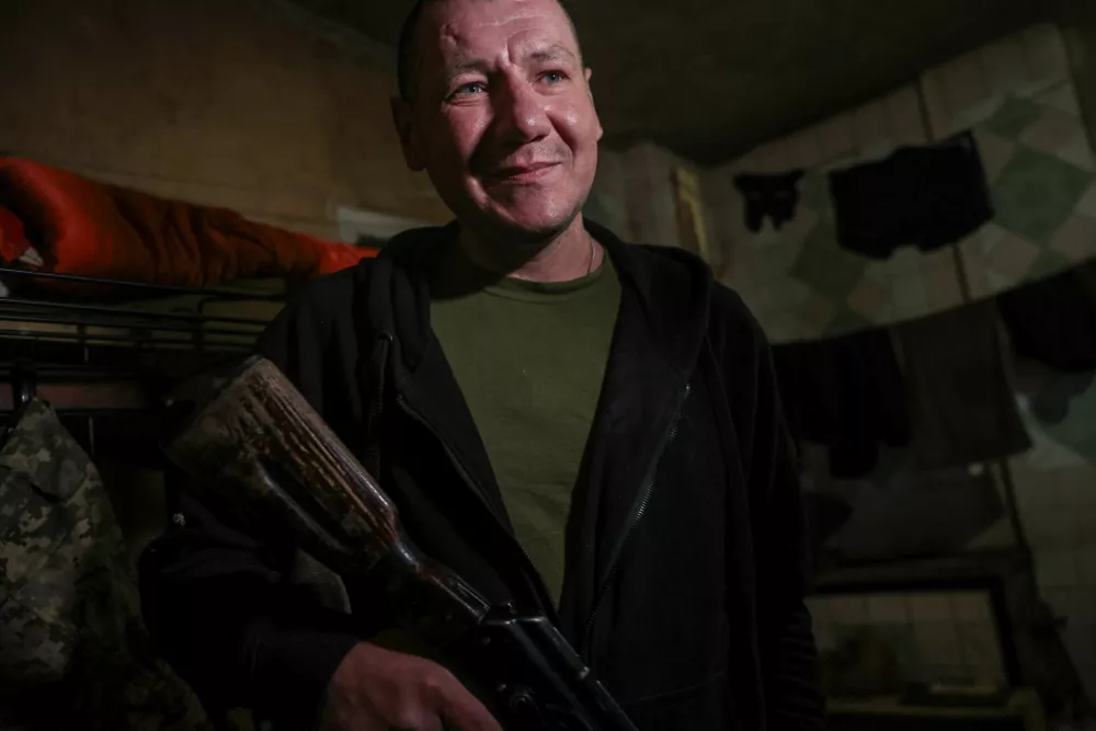 Serhii Krynitskyi, 42, a serviceman of the 24th Separate Mechanized Brigade of the Ukrainian Armed Forces, who spent 346 days at an isolated frontline position in the town of Chasiv Yar, Donetsk region, carries an AK assault rifle on his first day back on duty after recovery, amid Russia's attack on Ukraine, in the frontline city of Kramatorsk in Donetsk region, Ukraine, May 27, 2026. REUTERS/Alina Smutko