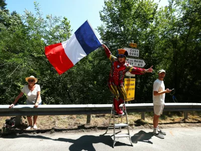 Cycling - Tour de France - Stage 17 - Chambery to Voiron - Chambery, France - July 22, 2026 A spectator waves the French flag during stage 17 REUTERS/Gonzalo Fuentes