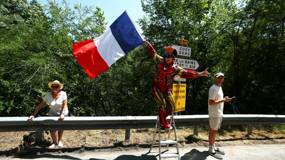 Cycling - Tour de France - Stage 17 - Chambery to Voiron - Chambery, France - July 22, 2026 A spectator waves the French flag during stage 17 REUTERS/Gonzalo Fuentes