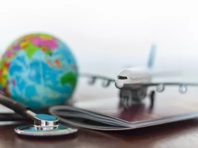 Healthcare and travel insurance concept. Stethoscope, passport document, airplane and globe / Foto: Rfranca Getty Images