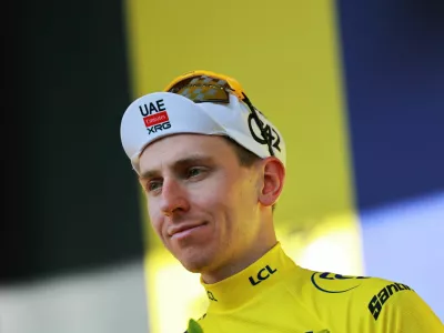 Cycling - Tour de France - Stage 17 - Chambery to Voiron - Voiron, France - July 22, 2026 UAE Team Emirates - XRG's Tadej Pogacar celebrates on the podium wearing the yellow jersey after stage 17 REUTERS/Stephanie Lecocq