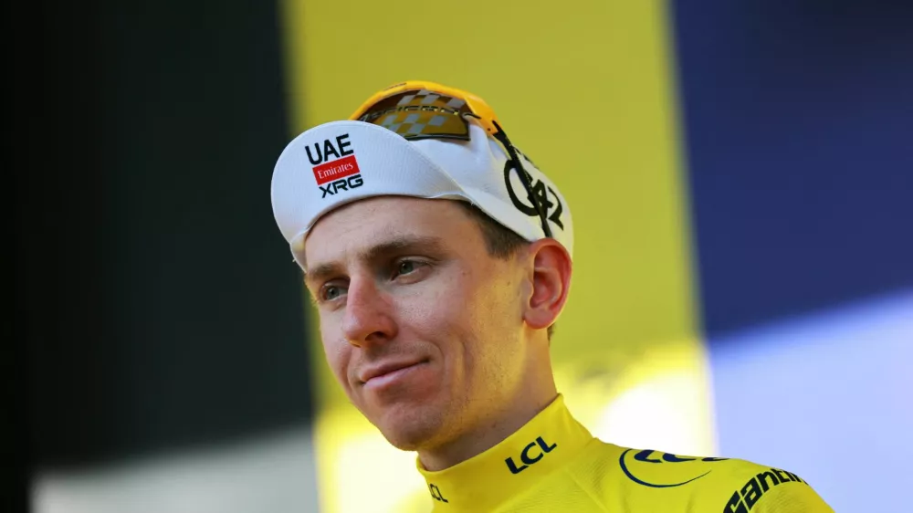Cycling - Tour de France - Stage 17 - Chambery to Voiron - Voiron, France - July 22, 2026 UAE Team Emirates - XRG's Tadej Pogacar celebrates on the podium wearing the yellow jersey after stage 17 REUTERS/Stephanie Lecocq