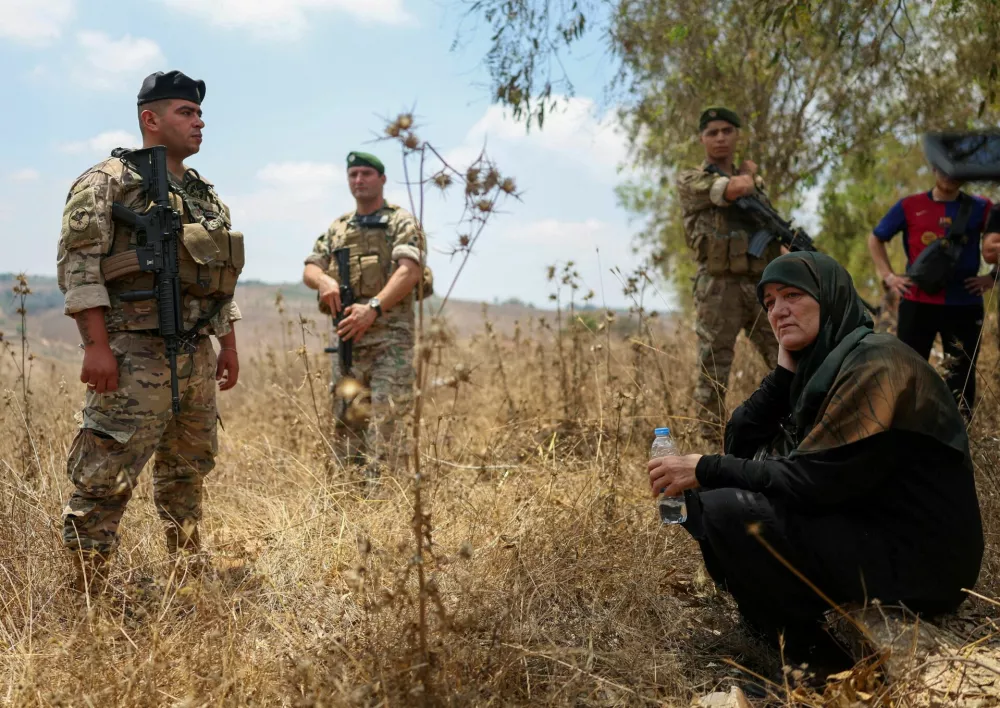 Lebanese army soldiers stand next to residents attempting to advance toward Zawtar al-Gharbiyeh, southern Lebanon, and push through a security cordon preventing access to the village, to reach their homes, after the withdrawal of Israeli forces under a U.S.-brokered plan, July 22, 2026. REUTERS/Zohra Bensemra   TPX IMAGES OF THE DAY