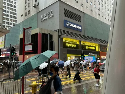 Passersby walk in Hong Kong's Mong Kok district under heavy rain and wind ahead of Typhoon Noul on Saturday, July 25, 2026. (AP Photo/Chan Ho-him)