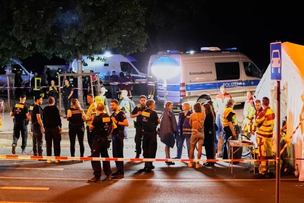 Emergency personnel and police gather in Berlin, early Sunday, July 26, 2026, following the cancellation of Christopher Street Day festivities. (AP Photo/Ebrahim Noroozi)