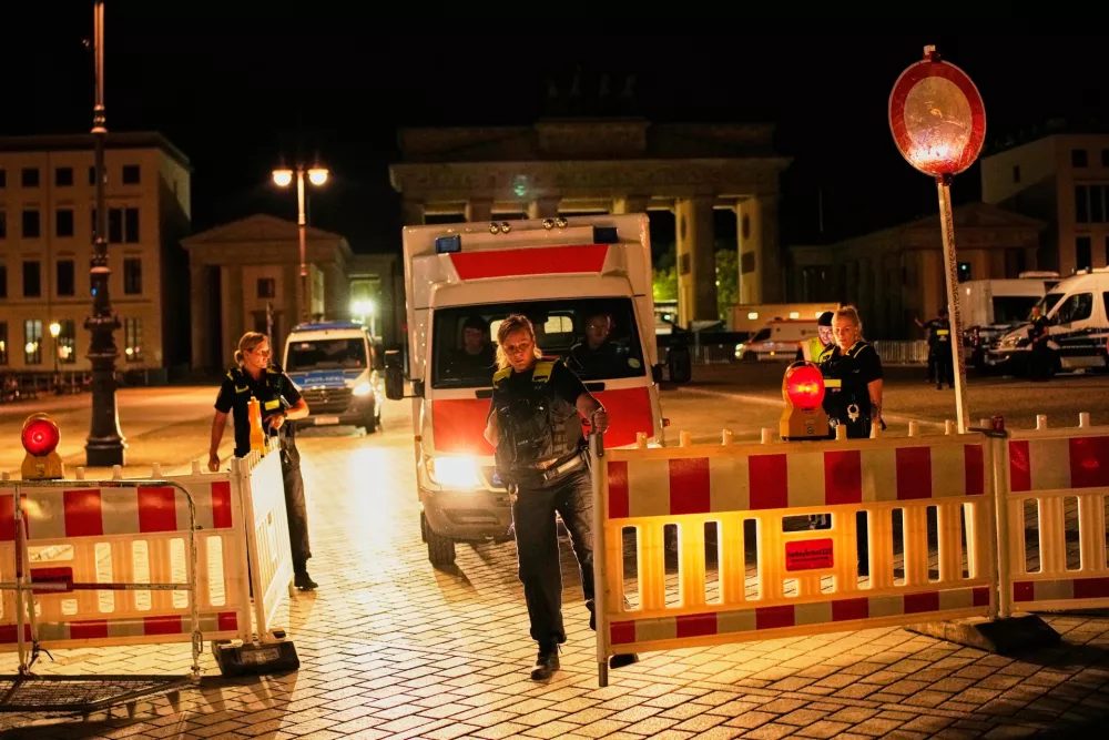 Police stand guard at the Brandenburg Gate following the cancellation of Christopher Street Day festivities in Berlin, Germany, early Sunday, July 26, 2026. (AP Photo/Ebrahim Noroozi)