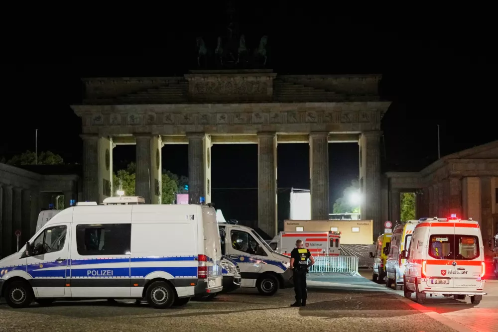 Police stand guard at the Brandenburg Gate following the cancellation of Christopher Street Day festivities in Berlin, Germany, early Sunday, July 26, 2026. (AP Photo/Ebrahim Noroozi)