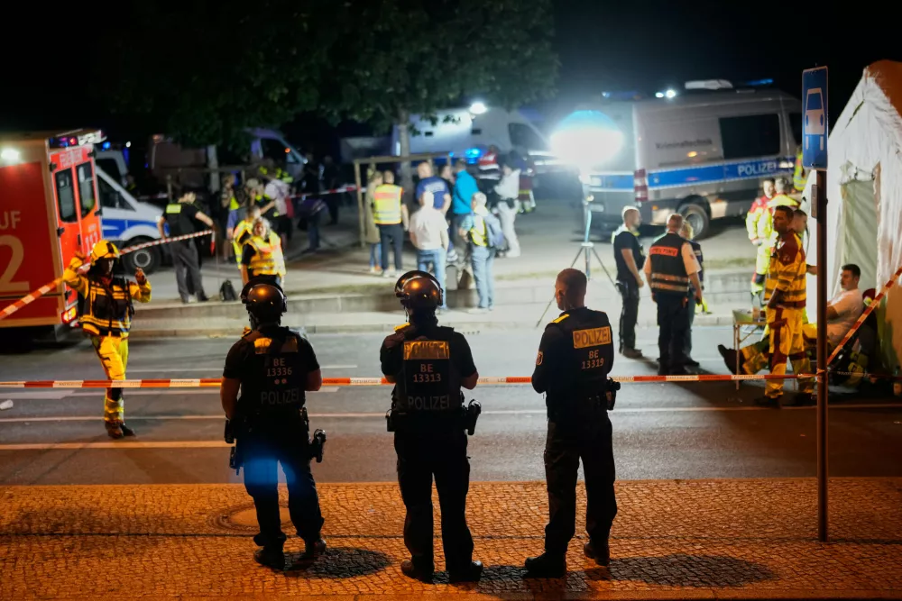 Emergency personnel and police gather in Berlin, early Sunday, July 26, 2026, following the cancellation of Christopher Street Day festivities. (AP Photo/Ebrahim Noroozi)