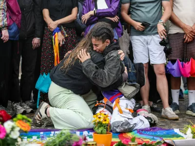 People hug each other as they gather at Brandenburg Gate, after a deadly incident in which a vehicle crashed into a crowd near Berlin's annual Christopher Street Day Pride parade on Saturday evening, leaving multiple people injured and the parade called off, in Berlin, Germany, July 26, 2026. REUTERS/Maryam Majd