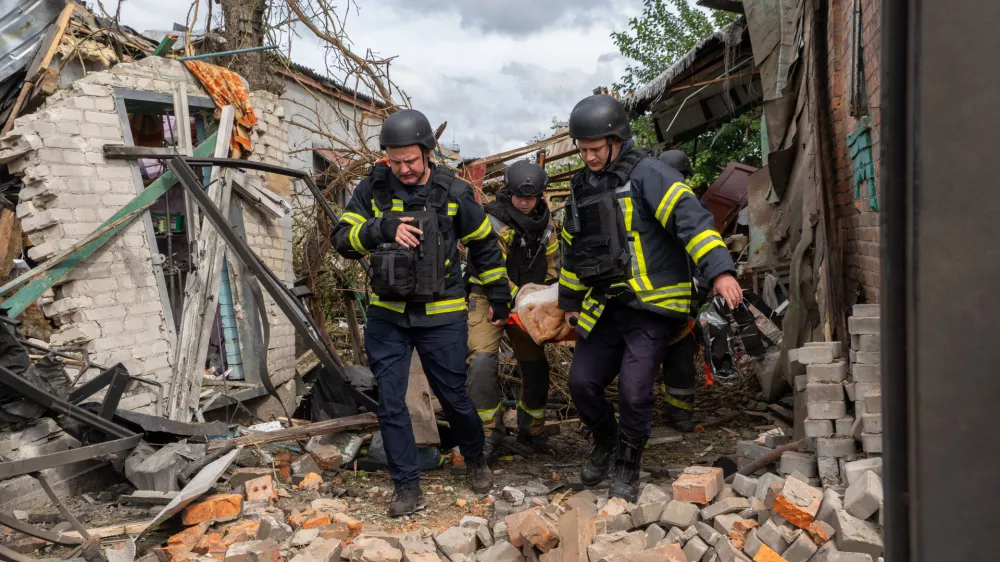 Rescuers carry a body that they removed from under the rubble of an private house following a drone attack from Russia, in Kharkiv, Ukraine, Sunday, July 26, 2026. (AP Photo/Andrii Marienko)