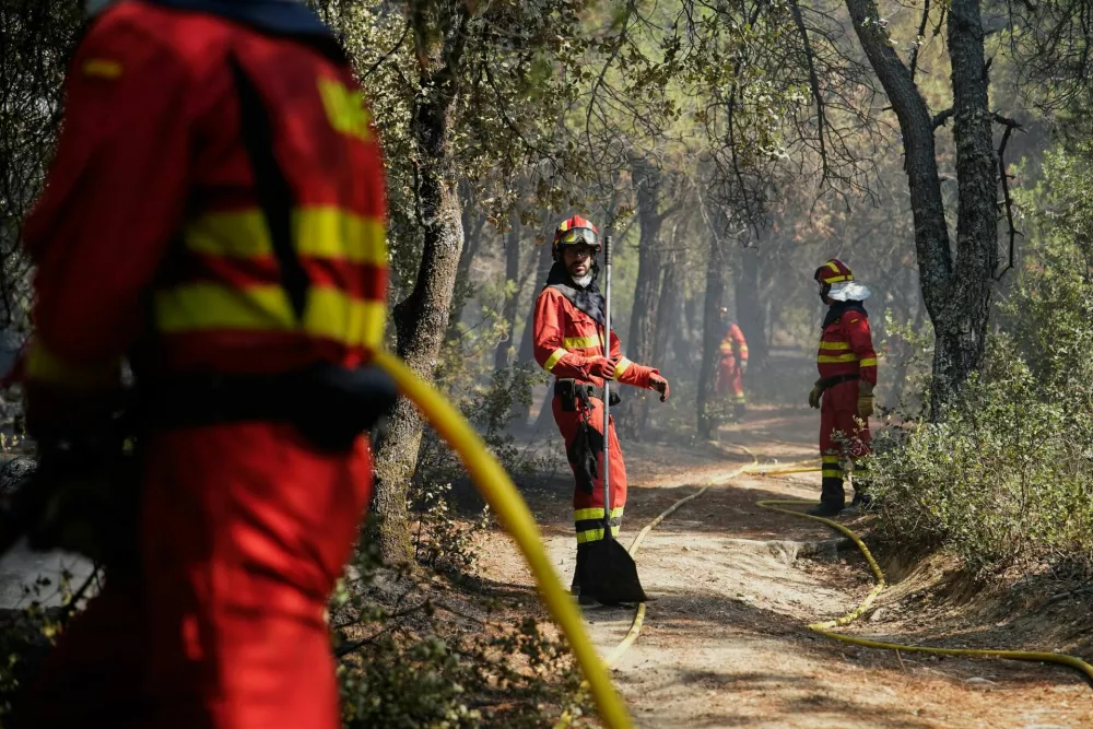 Members of the Military Emergencies Unit (UME) refresh the area after putting out a fire in San Martin de Valdeiglesias, Madrid, Spain July 26, 2026. REUTERS/Ana Beltran