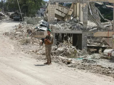 A member of the Lebanese army stands guard next to a destroyed building in Zawtar al-Gharbiyeh, after the withdrawal of Israeli forces under a US-mediated plan, in southern Lebanon, July 26, 2026. REUTERS/Aziz Taher