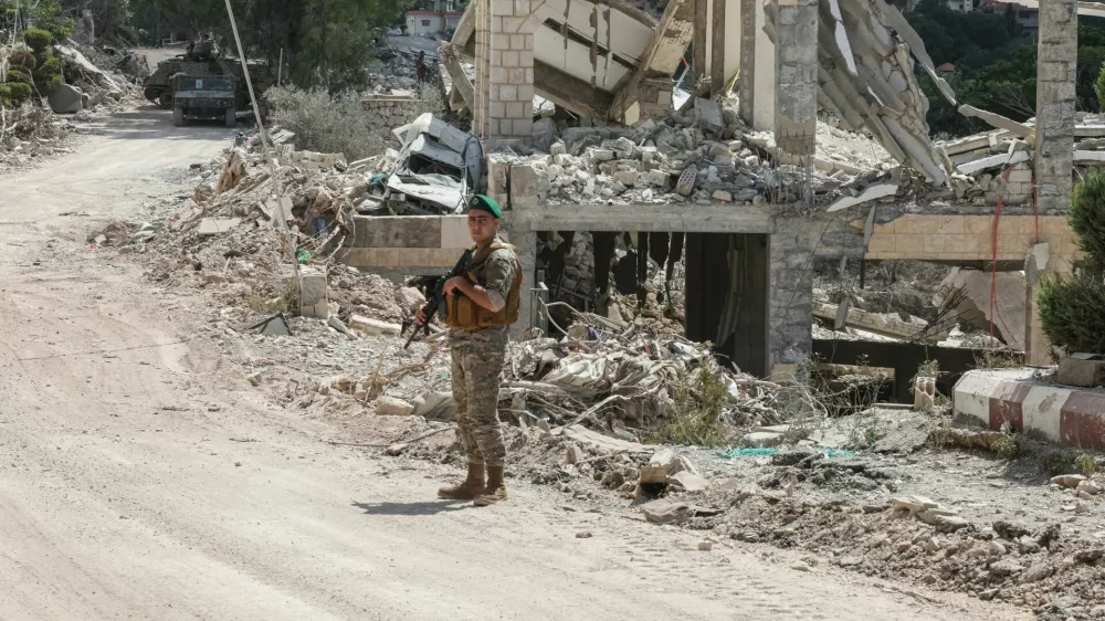 A member of the Lebanese army stands guard next to a destroyed building in Zawtar al-Gharbiyeh, after the withdrawal of Israeli forces under a US-mediated plan, in southern Lebanon, July 26, 2026. REUTERS/Aziz Taher