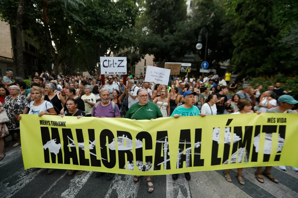 Demonstrators carry a banner during a protest against mass tourism and gentrification in the Balearic Islands, in Palma de Mallorca, Spain, July 26, 2026. REUTERS/Francisco Ubilla
