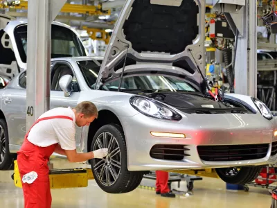 Porsche employees assemble Panameras at the Porsche plant in Leipzig, Germany, 04 September 2014. After the opening of the Macan plant in February 2014, the Leipzig plant is being expanded again at a cost of 500 million euro. The Panamera will be completely manufactured in Leipzig starting in 2016. The production area will be doubled and jobs will be created for 200 engineers as well as several hundred other employees. Photo by: Jan Woitas/picture-alliance/dpa/AP Images