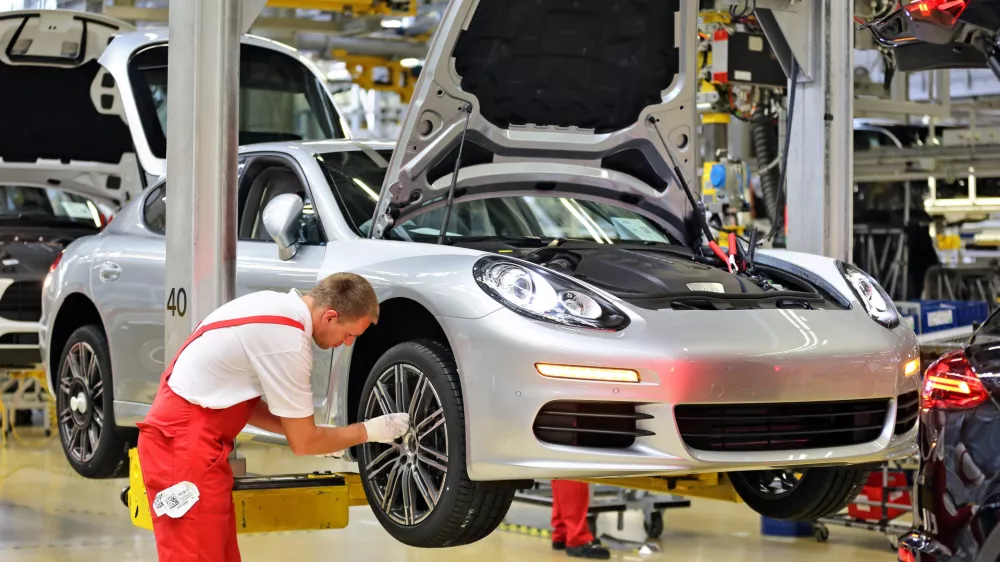 Porsche employees assemble Panameras at the Porsche plant in Leipzig, Germany, 04 September 2014. After the opening of the Macan plant in February 2014, the Leipzig plant is being expanded again at a cost of 500 million euro. The Panamera will be completely manufactured in Leipzig starting in 2016. The production area will be doubled and jobs will be created for 200 engineers as well as several hundred other employees. Photo by: Jan Woitas/picture-alliance/dpa/AP Images