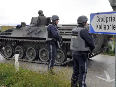 Austrian army soldiers in an armored vehicle arrive near the villages of Grosspriel and Kollapriel some 90 kilometers (55 miles) west of Vienna, Austria, Tuesday, Sept. 17, 2013, where a man is barricading himself inside a farm building after he killed two police officers and the driver of an emergency rescue vehicle as the dpa news agency said, citing an unidentified police spokesman. Interior Minister spokesman Karl-Heinz Grundboeck said a third police officer was apparently being held by the shooter in the village of Kollapriel. He confirmed that three people were shot but refused to say whether their injuries were fatal, explaining that officials did not want to give the gunman information through news reports he was likely monitoring. (AP Photo/Hans Punz)