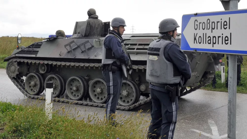 Austrian army soldiers in an armored vehicle arrive near the villages of Grosspriel and Kollapriel some 90 kilometers (55 miles) west of Vienna, Austria, Tuesday, Sept. 17, 2013, where a man is barricading himself inside a farm building after he killed two police officers and the driver of an emergency rescue vehicle as the dpa news agency said, citing an unidentified police spokesman. Interior Minister spokesman Karl-Heinz Grundboeck said a third police officer was apparently being held by the shooter in the village of Kollapriel. He confirmed that three people were shot but refused to say whether their injuries were fatal, explaining that officials did not want to give the gunman information through news reports he was likely monitoring. (AP Photo/Hans Punz)
