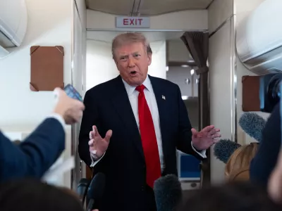 President Donald Trump speaks with reporters while on Air Force One en route to Oakland County International Airport, Monday, July 27, 2026, in Waterford Township, Mich. (AP Photo/Alex Brandon)