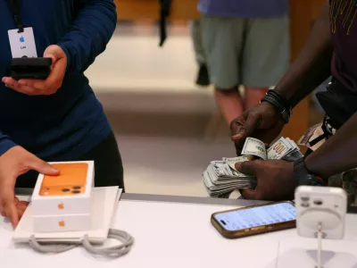 FILE PHOTO: A man purchases an iPhone 17 series with cash at the Apple Store in New York City, U.S., September 19, 2025. REUTERS/Shannon Stapleton/File Photo