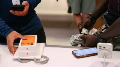 FILE PHOTO: A man purchases an iPhone 17 series with cash at the Apple Store in New York City, U.S., September 19, 2025. REUTERS/Shannon Stapleton/File Photo