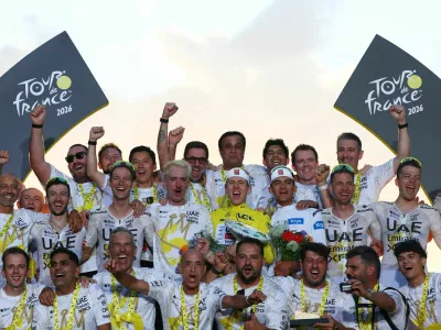 Cycling - Tour de France - Stage 21 - Paris, France - July 26, 2026 UAE Team Emirates XRG's Tadej Pogacar celebrates on the podium while wearing the yellow jersey after winning the Tour de France, alongside UAE Team Emirates XRG's Isaac Del Toro wearing the white jersey and the UAE Team Emirates XRG team REUTERS/Gonzalo Fuentes