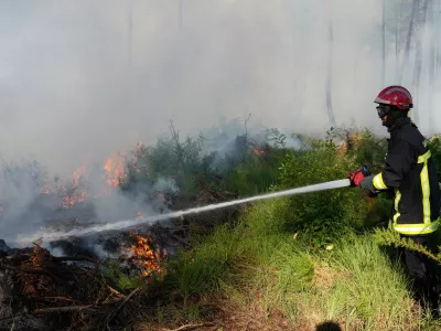 A firefighter works to suppress flames near Lacanau, as wildfires rage outside Bordeaux, France, Monday, July 27, 2026. (AP Photo/Baz Ratner)