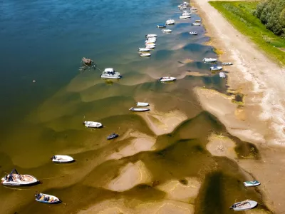 Boats sit on a bank of the Danube River where usually submerged areas are exposed due to extremely low water levels following an extended period of drought in Islaz, Romania, Wednesday, July 29, 2026. (AP Photo/Nicolae Dumitrache)