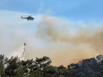 A firefighting helicopter makes a water drop as a wildfire burns next to the village of Plomari on the island of Lesbos, Greece, July 29, 2026. REUTERS/Elias Marcou