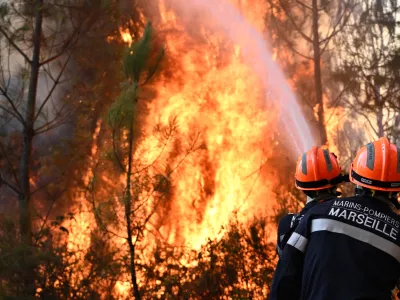 Firefighters work to extinguish a fire in the forest near Blagon, during wildfires in southwestern France, Wednesday, July 29, 2026. (AP Photo/Emma Da Silva)