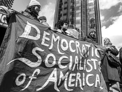 March 28, 2026, New York, New York, USA: A black-and-white photograph shows demonstrators holding a Democratic Socialists of America banner during the No Kings protest in Manhattan, with Trump International Hotel and Tower in the background. (Credit Image: &copy; Bianca Otero/ZUMA Press Wire)
