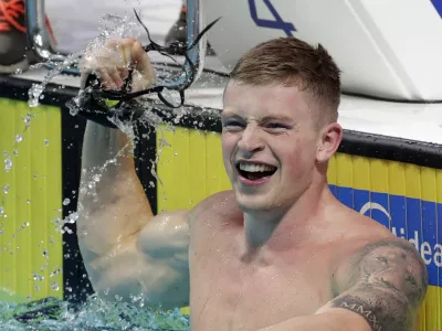 Britain's Adam Peaty celebrates after setting a new world record in a men's 50-meter breaststroke semifinal during the swimming competitions of the World Aquatics Championships in Budapest, Hungary, Tuesday, July 25, 2017. (AP Photo/Michael Sohn)